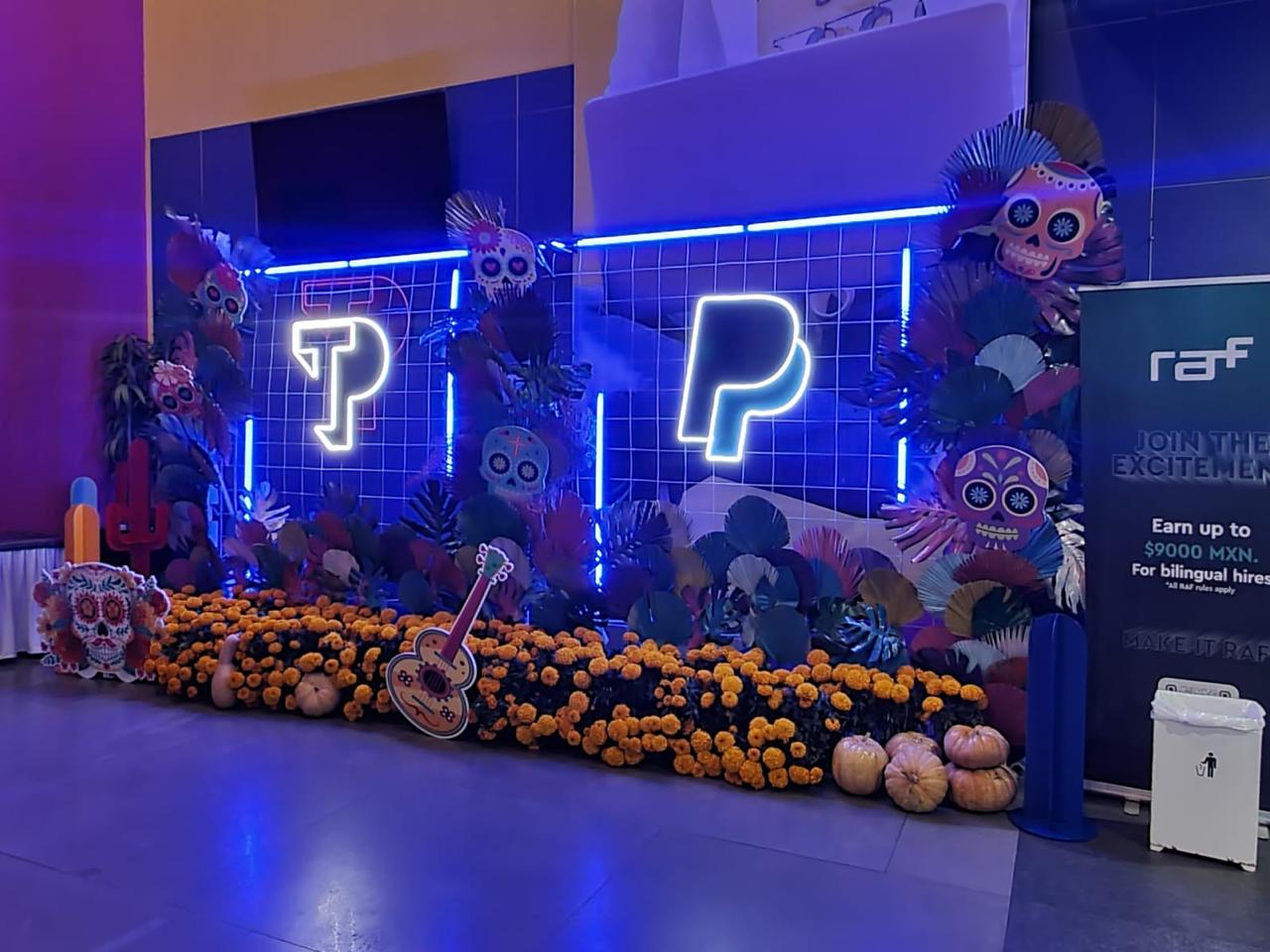 Decoración Día de Muertos Teleperformance con neon y cempasúchil